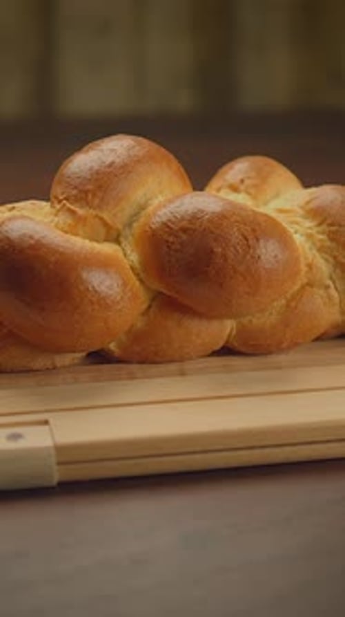 Deliciously Freshly Baked Braided Bread Spread Out Beautifully on a Rustic Wooden Surface