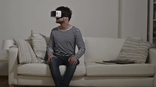 Man Wearing Virtual Reality Goggles. Studio, White Couch