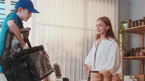 An Asian delivery man wearing blue uniform sending food