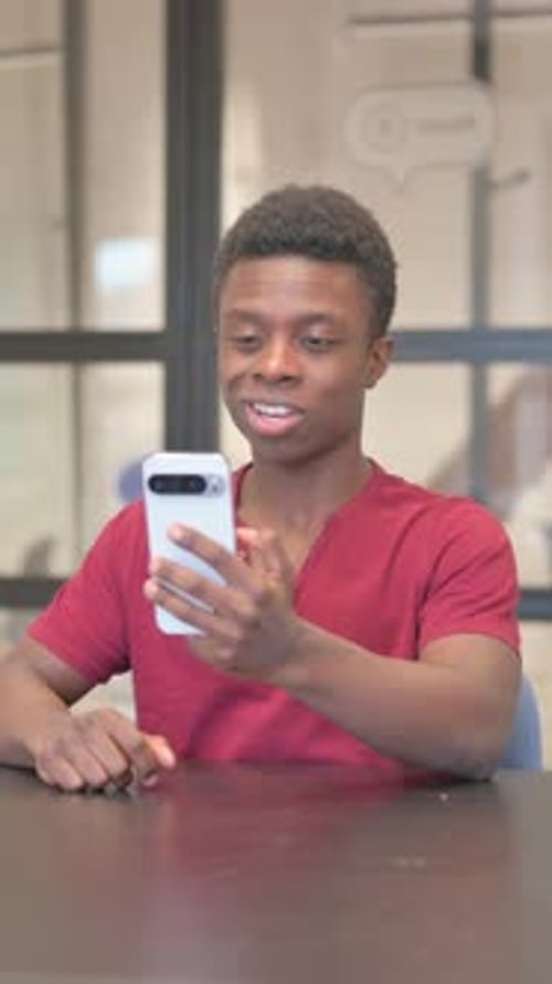 vertical video of African Man Doing Video Chat on Phone in Office