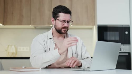 Concentrated Man Working By Computer and Rubbing Temple with Painful Grimace