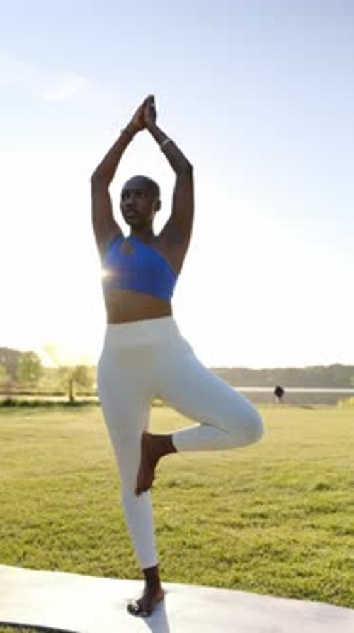 African American Woman Performing Yoga Tree Pose Outdoors