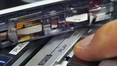 Finger Pressing Play on Vintage Cassette Player