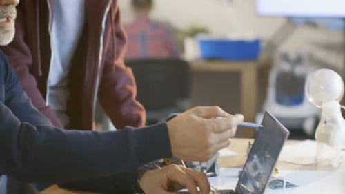 In Computer Science Class Teacher Examines Sketches of a programed Robot Engineered by Girl and Boy