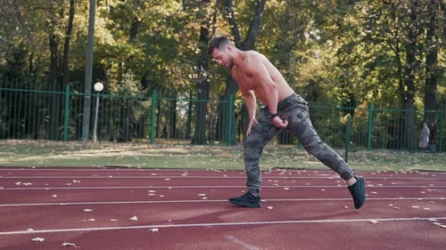 Muscular Man Warming Up Doing Lunges Outdoors