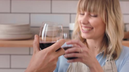 Couple Toasting with Red Wine in Kitchen