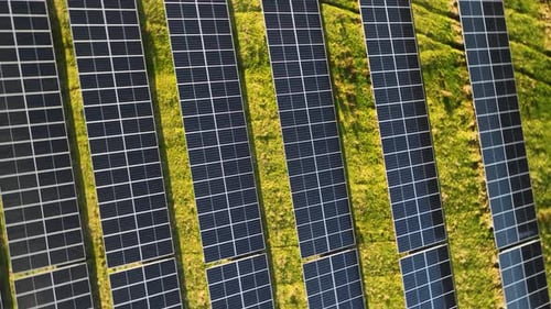 Aerial footage of photovoltaic arrays on open spaces.