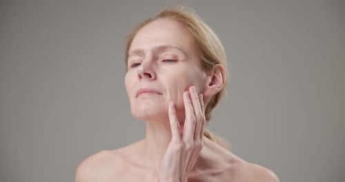 Woman Touches Her Face in Studio Close Up