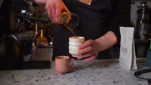 Close up of barista preparing filter coffee in a modern coffee shop.
