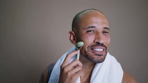 Man Using Jade Facial Roller as Part of Skincare