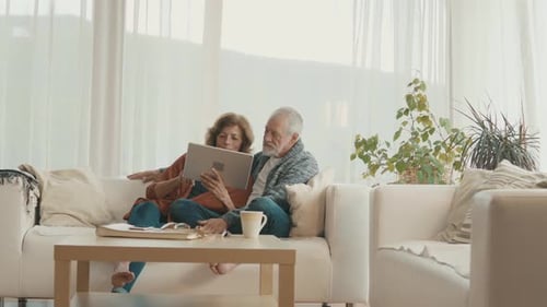 Senior Couple Relaxing at Home Using a Tablet