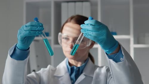 Scientist Examining Test Tubes with Blue Liquid