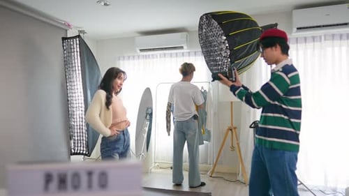 Asiatisches Frauenmodel wird von einem Kameramann in einem Fotostudio fotografiert.