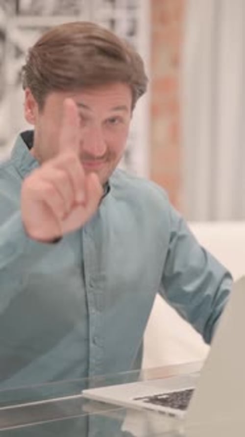 Yes, Adult Man Pointing Finger while Working on Laptop, vertical