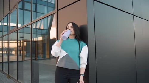 Woman Drinks Water From Reusable Bottle