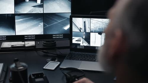 Security Guard Monitoring Video Footage in Control Room