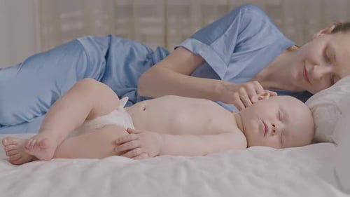 Sleeping Baby with Young Woman in a Bedroom