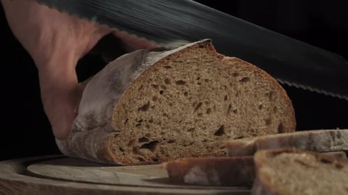 Slicing a Loaf of Bread on a Board