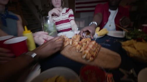 POV of Multiethnic Friends Eating Hot Dogs during Independence Day Party