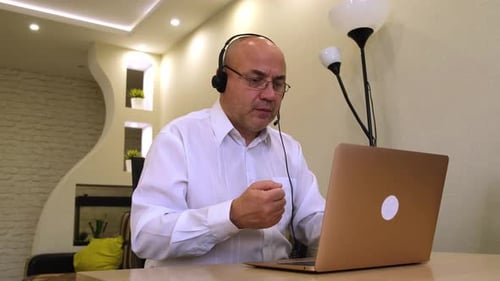 Man Teleconferencing at Desk in Home Office