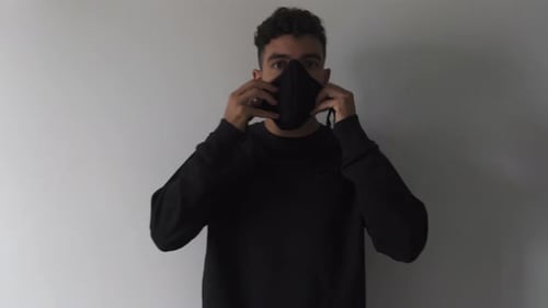 Young Adult Puts on Black Mask