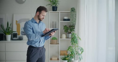 Man Using Tablet with Stylus in Bright Home