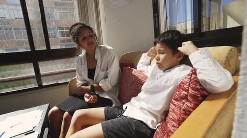 Young Patient Talking to Child Psychologist in Her Office