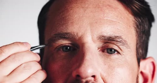 Man, eyebrows and hair removal with tweezer for epilation or grooming on a white studio background