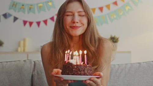 Woman Smiles and Blows out Birthday Candles