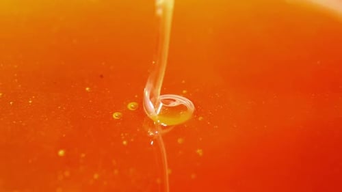Golden Honey Stream Falling Into Amber Liquid