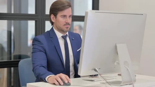 Junger Geschäftsmann arbeitet am Desktop