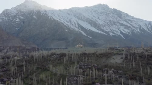 Luftaufnahme eines ruhigen Tals in Pakistan mit einem weißen Gebäude mit Kuppel und Schneedecke