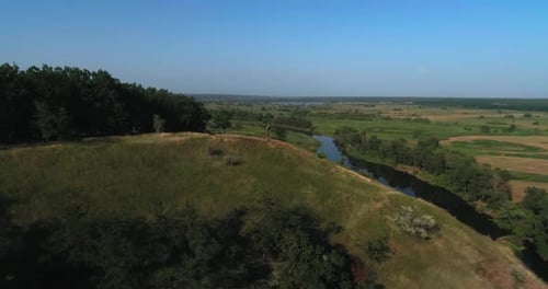 Drone Shoot of Small Rural Farm Under Blue River Near Pine Forest