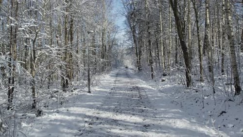 Empty Rural Road Covered In Fresh Snow During Winter. Zoom Out Shot