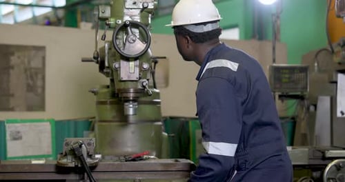 Man Operating Industrial Machine in Factory Setting