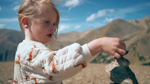 Tourist Child Reached Summit on Mountain Path at Vacation and Put Rock on Cairn