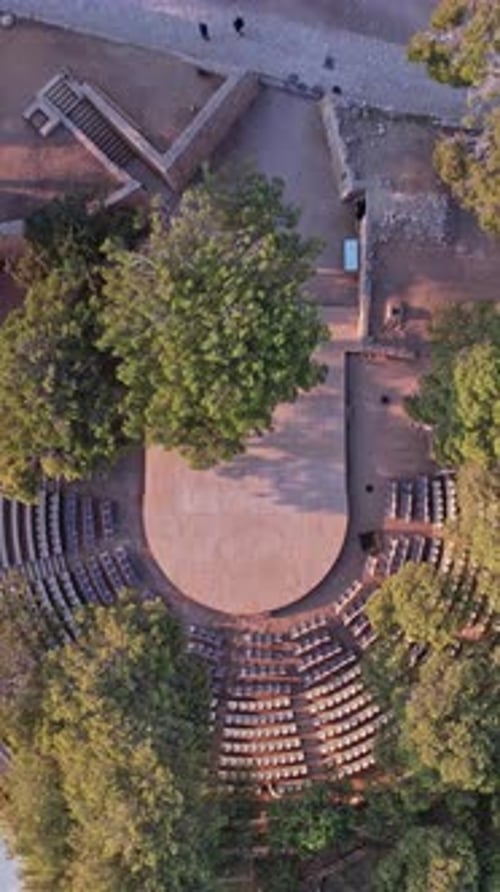 Amphithéâtre extérieur éclairé par la lumière du jour dans un cadre boisé historique