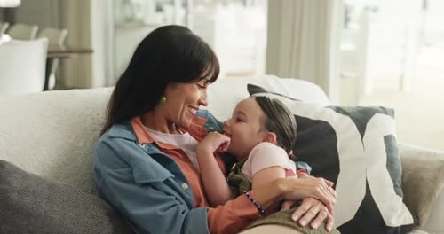 Smiling Woman and Child Embrace on Couch