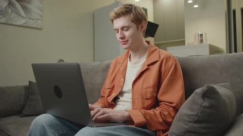 Man Working on Laptop at Home on Couch