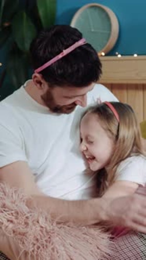 Loving Father and Daughter Embrace in Bed