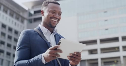 Happy, laughing and reading on tablet after receiving an email about good news