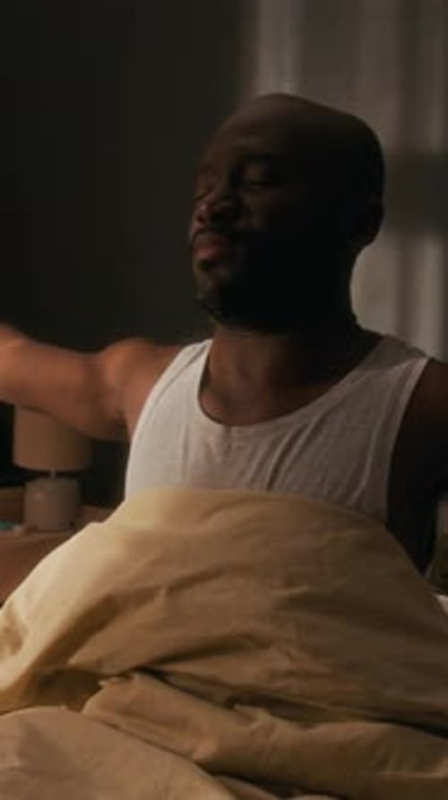 Man Sitting up in Bed in Morning