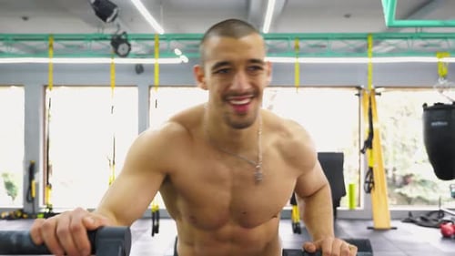 Muscular Man Exercising on Machine at Gym