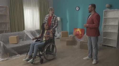 A Man with an African American Woman on a Wheelchair Inspect an Apartment for Purchase Rent The