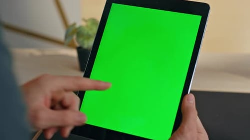 Person using tablet with green screen
