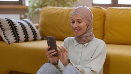 Smiling Woman with Headscarf Using Mobile Phone