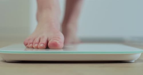 Bare Feet Stepping on a Weight Scale