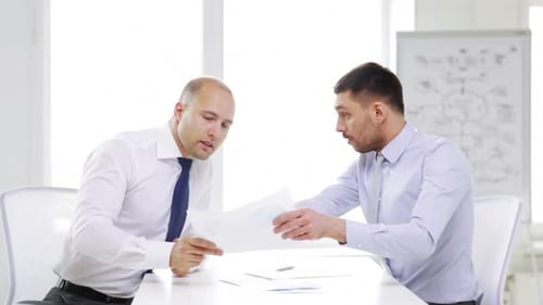 Serious hispanic businessmen discussing corporate financial papers in the office