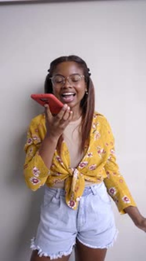 Smiling Woman Using Voice Message on Cellphone
