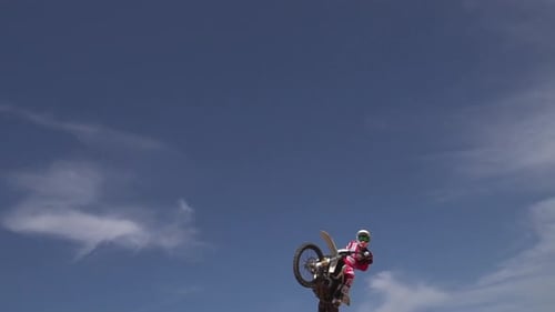 Motocross Rider Performs Jump Stunt on Dirt Track